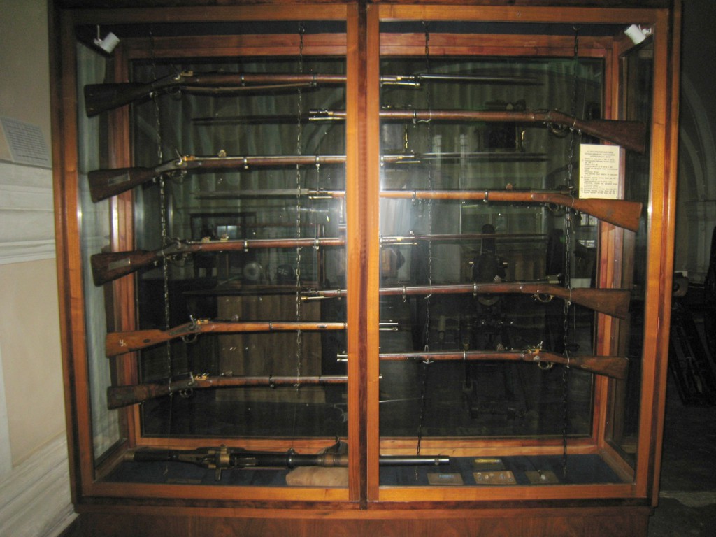 Výstavní vitrína se zbraněmi druhé poloviny 19. století, nabíjené zezadu. V dolní části vitríny leží hradebnice Krnka-Gan 1876